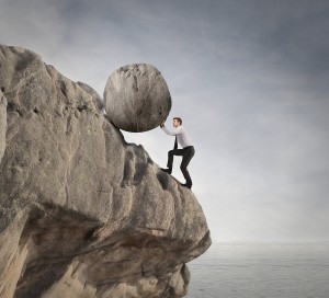 fatigued businessman supports large boulder